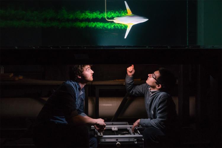 two students look at an aerodynamic test of a model airplane