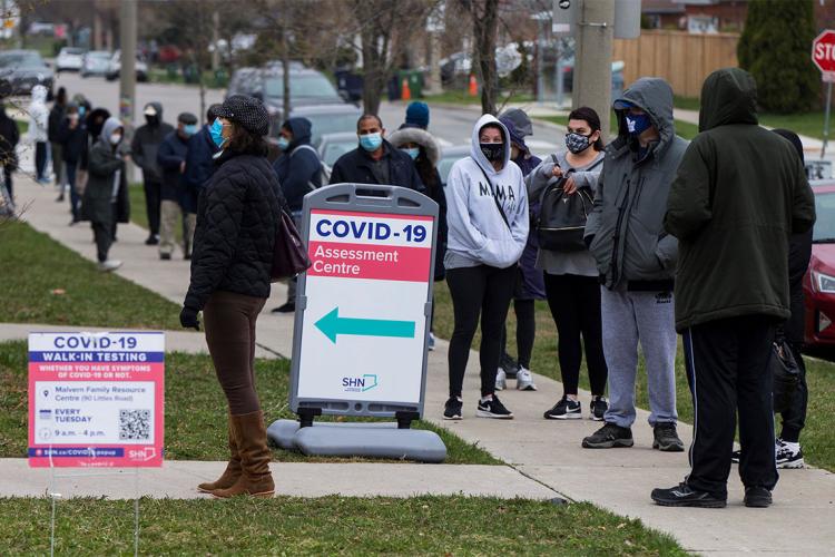 racialized people line up for a covid test in toronto