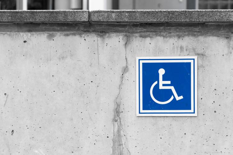 Handicapped parking sign on a concrete wall