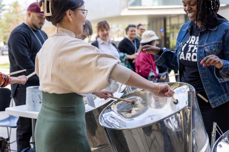 a woman plays the steel drum at an outdoor event at UTSC