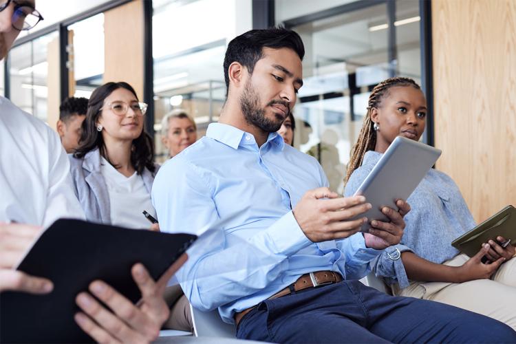 Working professionals in a workshop setting, holding tablets