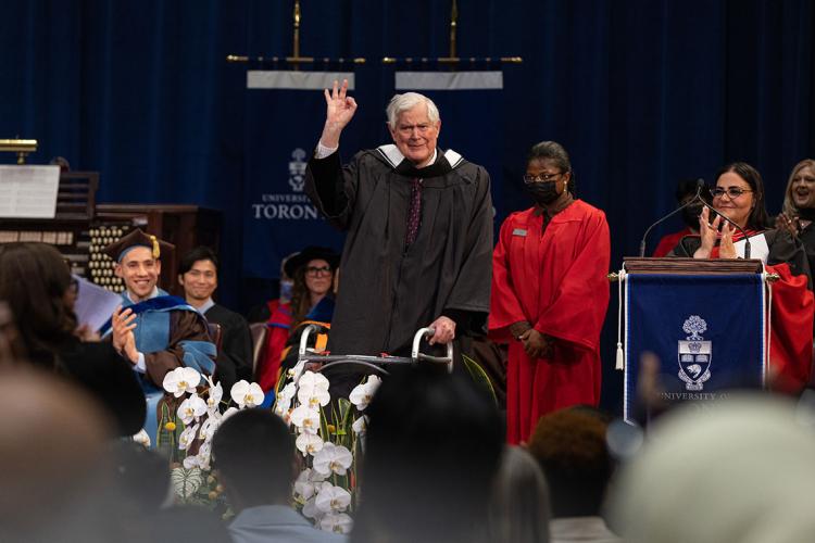 John Bond gives the OK sign on stage during convocation