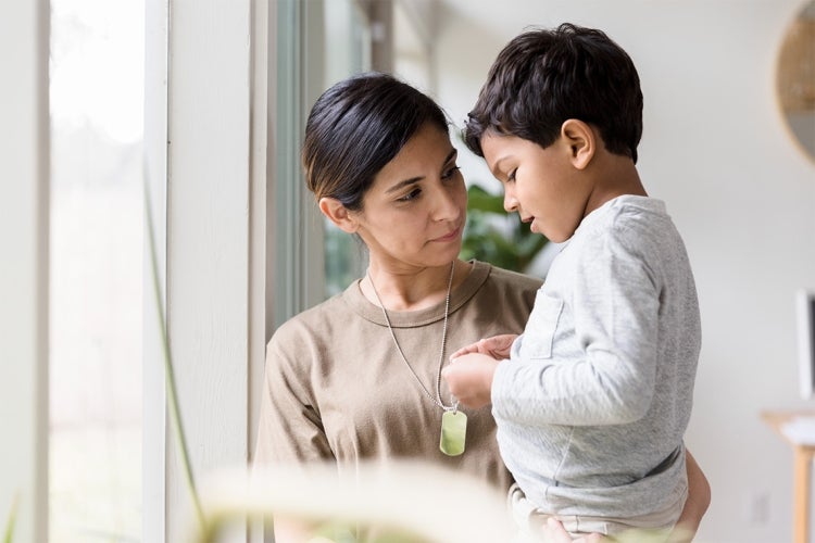 a young boy speaks to his mother