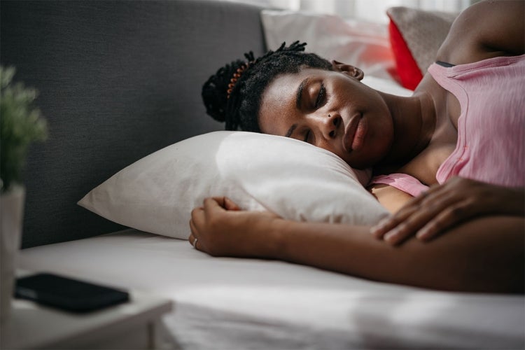 a black woman is sleeping in bed at home