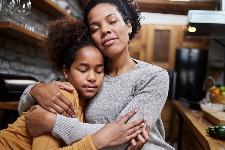 A mother consoles her adolesent daughter 