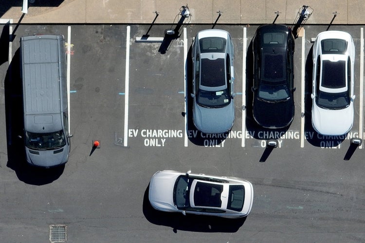An overhead view of electric vehicles and designated spaces in a parking lot