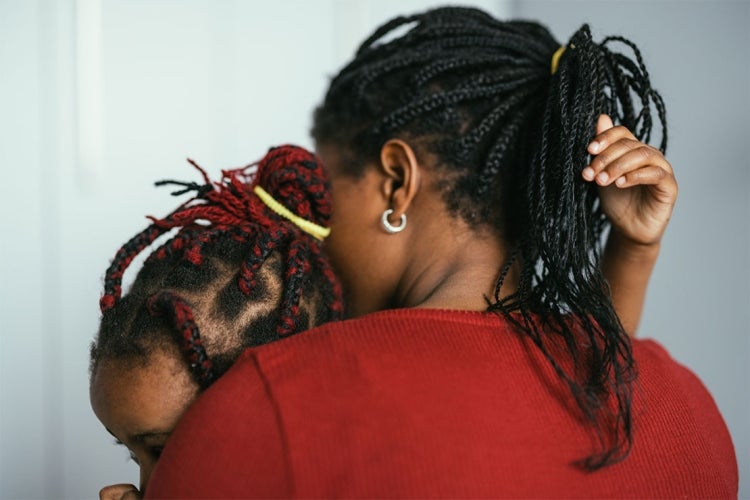 a Black mother holds her young daughter