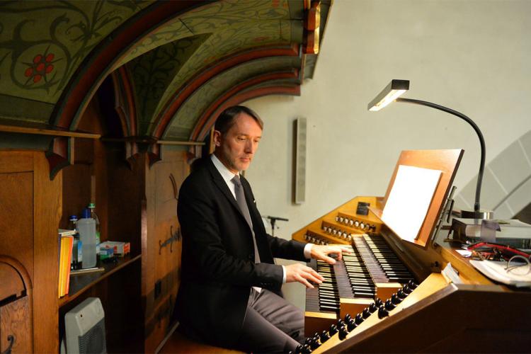 Orgnaist Olivier Latry sits at an organ