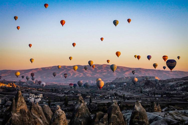 Photo of balloons taking to the sky over  Göreme,Turkey