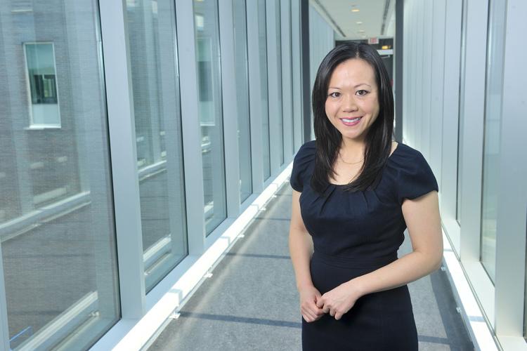 Photo of Cindy Chan standing in a glass hallway