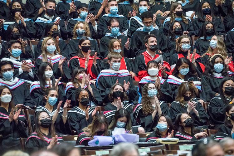 Masked students seated inside Convocation Hall