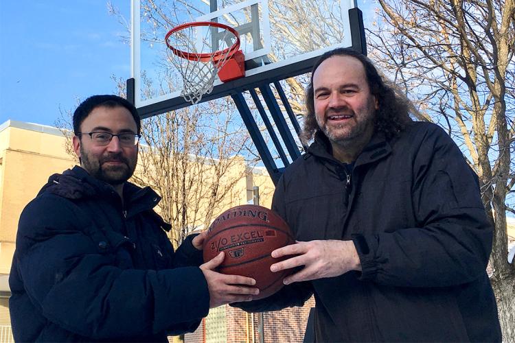 Daniel and Jeffrey Rosenthal hold a basketball together outside