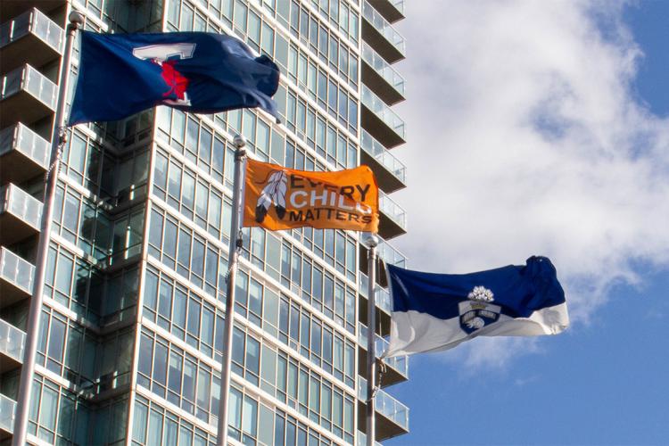 Varsity Blues flag, Every Child Matters flag and the University of Toronto flag are flown at Varsity Stadium in downtown Toronto