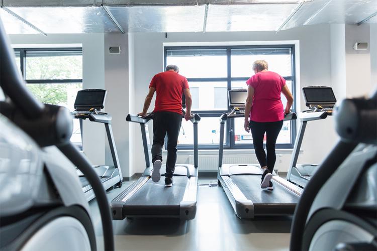 two senior citizens excercising on treadmills