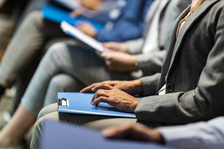 a row of job applicants wait nervously