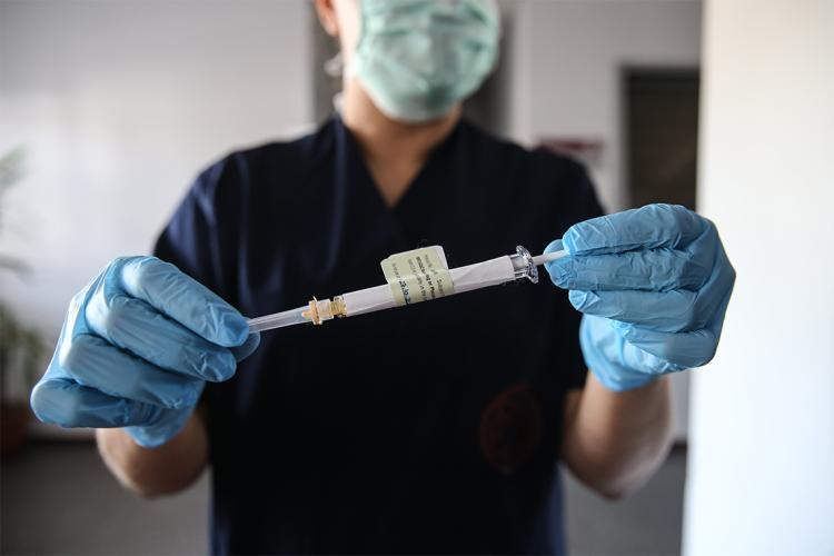 person holds a syringe filled with the stage 3 trial of the pfizer vaccine