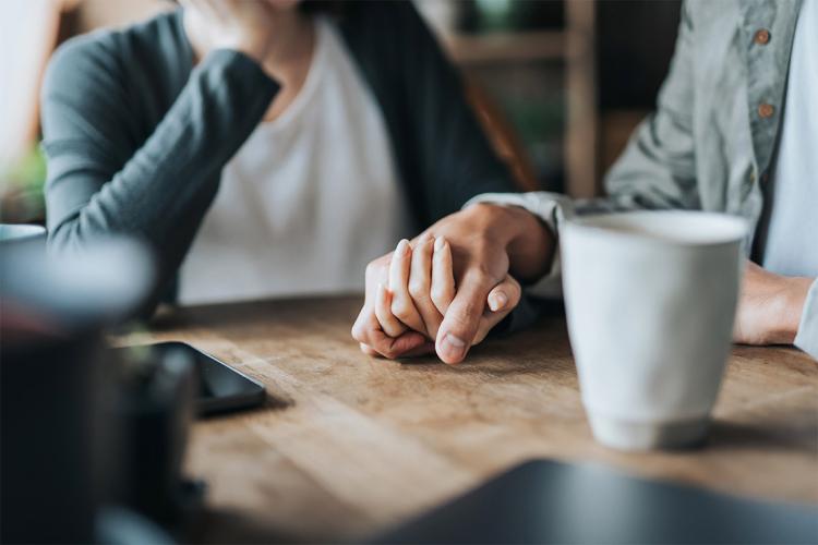 a man and a woman hold hands affectionately 