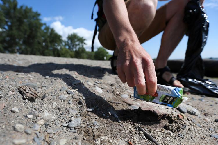 a man picks up litter on a Toronto beach