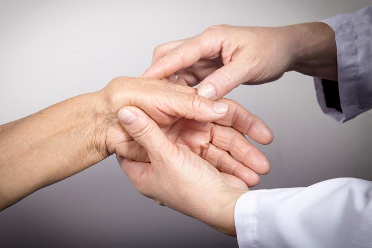 photo of a doctor examining a patient's hands