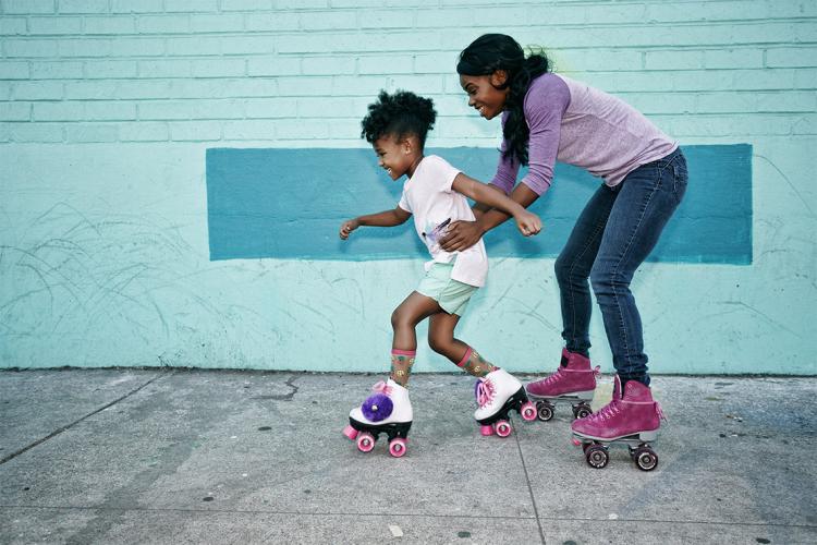 mother helps daughter roller skate