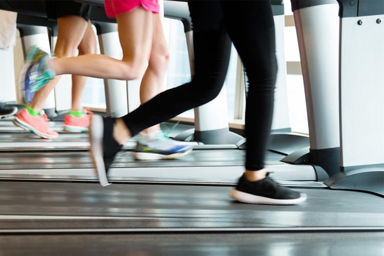 Waist-down photo of people exercising on treadmills