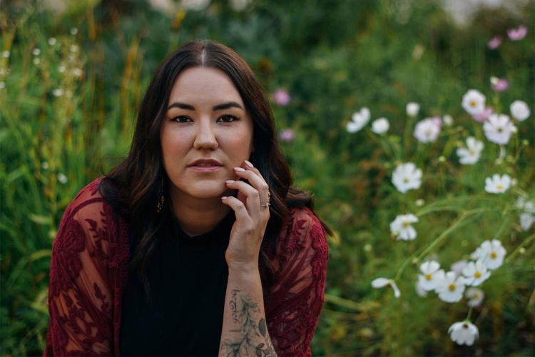 Portrait of Karen McBride taken outside with flowers in the background