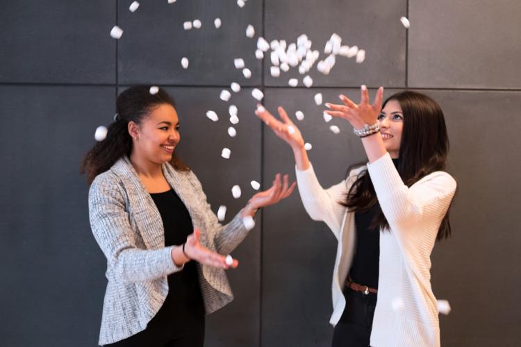 Students and Enactus U of T members Anne Ageh and Nuha Siddiqui toss prototypes of EcoPacker's eco-friendly packing peanuts in the air