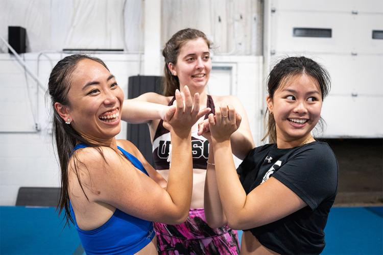 Three members of the UTSC cheer club share at laugh 