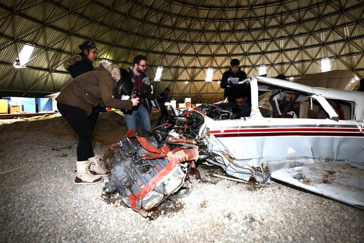 photo of students inspecting a staged plane crash