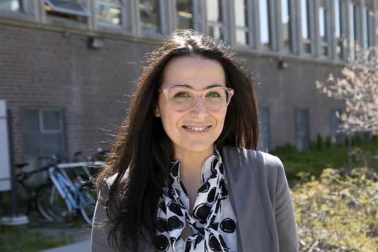 photo of Neda Maghbouleh standing in front of a building with a bike rack