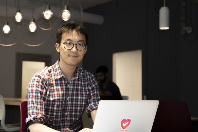 Albert Tai working on a laptop at On Ramp located at U of T