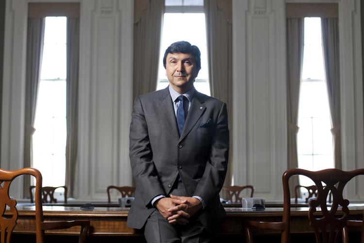 portrait of David Naylor leaning against a large table at Simcoe Hall