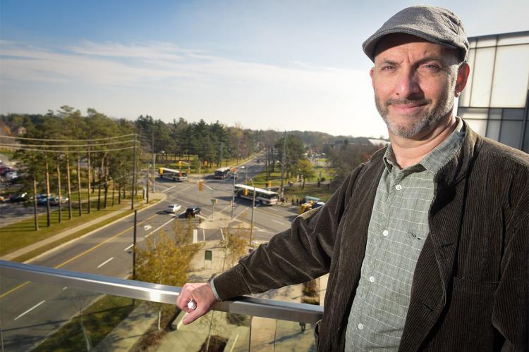 Andre Sorenson on a balcony overlooking a traffic intersection in Scarborough