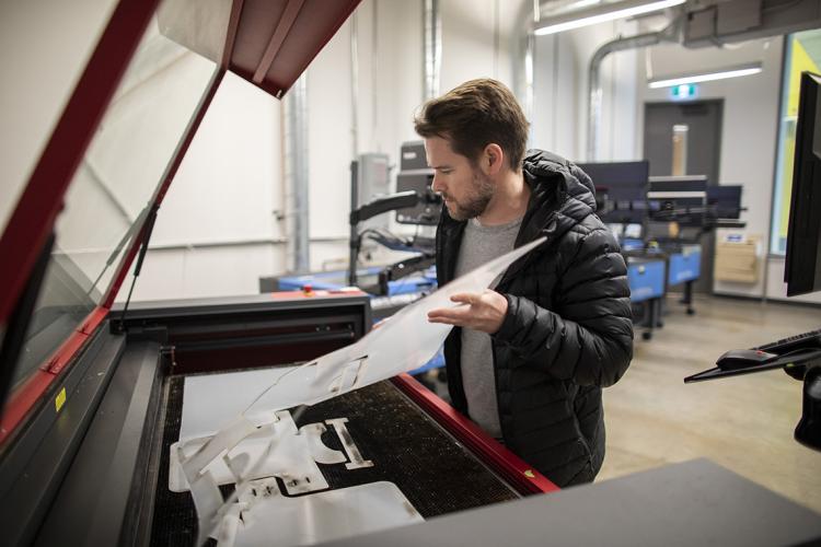 Mike Doell taking out a sheet of 3d printed material