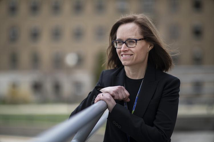 Photo of Jeannie Callum of U of T and Sunnybrook as she leans on a railing with a building in the background