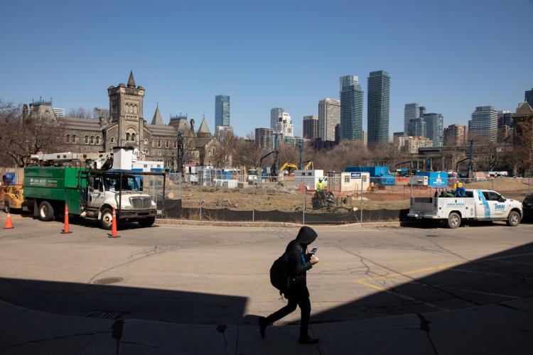 A student walks by construction on Front Campus