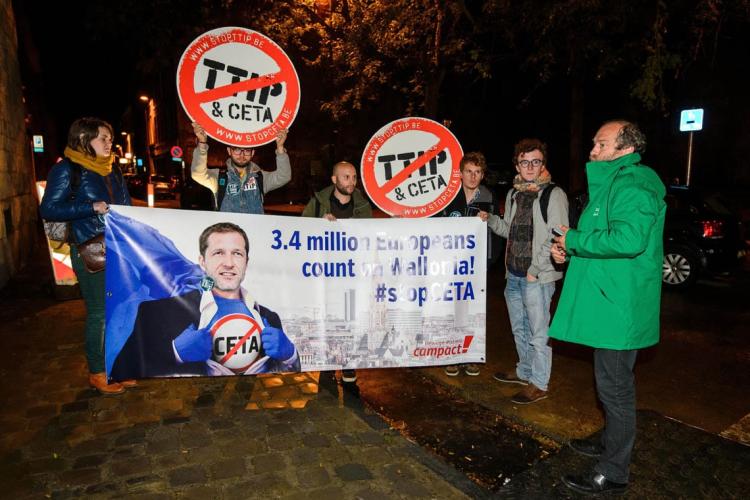 Protesters hold up a placard reading '3.4 million Europeans count on Wallonia - stop CETA' as a meeting on CETA takes place at the Walloon parliament in Namur, Belgium