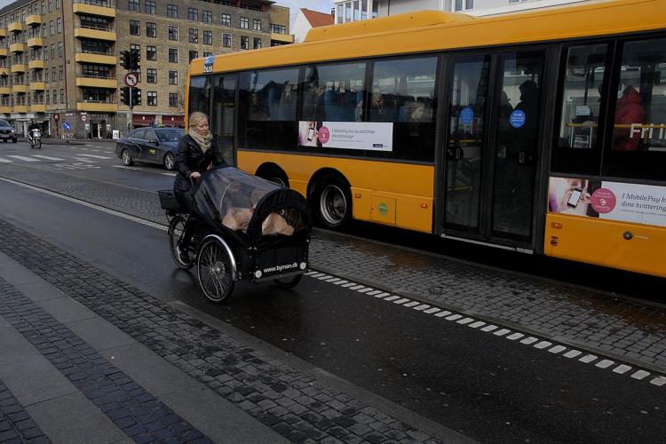A female cyclist and a bus in Copenhagen