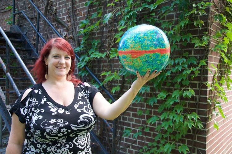 Renée Hložek holding a globe