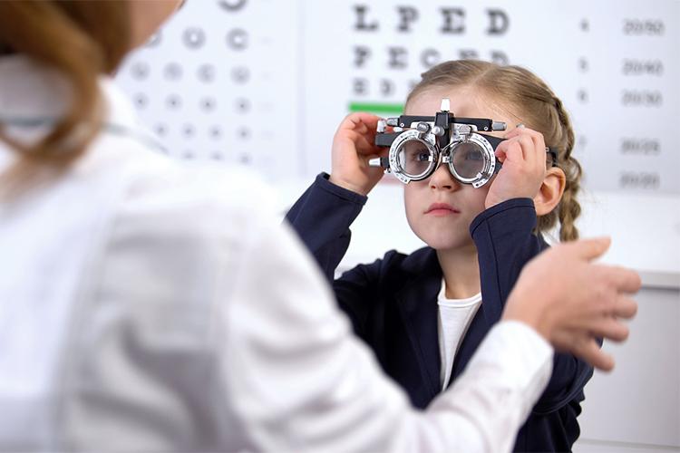a young girl, about age 6, taking an eye exam