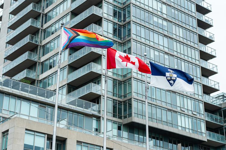 pride flag flies next to the canadian flag and u of t flag at varsity stadium