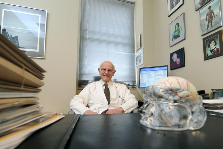 Photo of Dr. Charles Tator at his desk