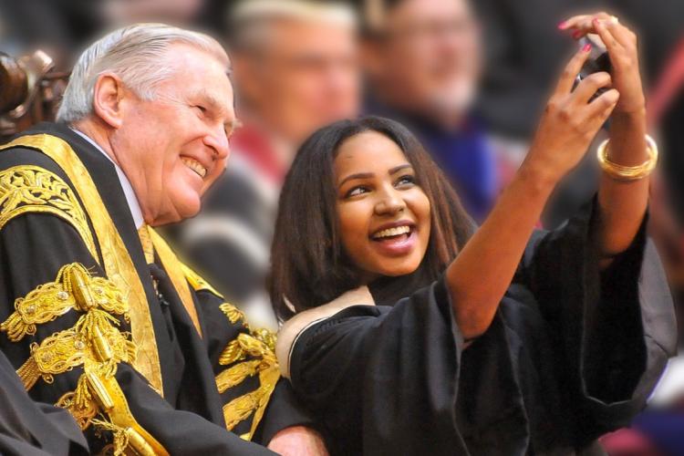 a student takes a selfie with chancellor michael wilson