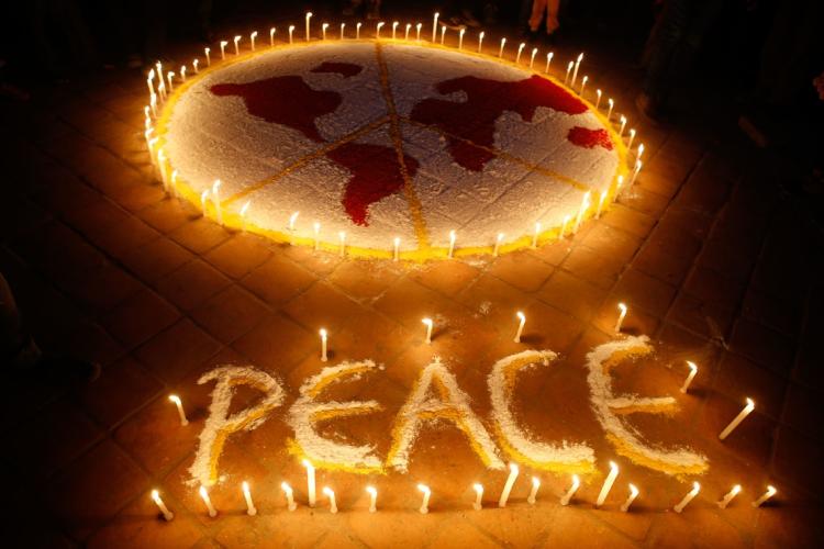 photo of a peace sign written in candles and a drawing of the world