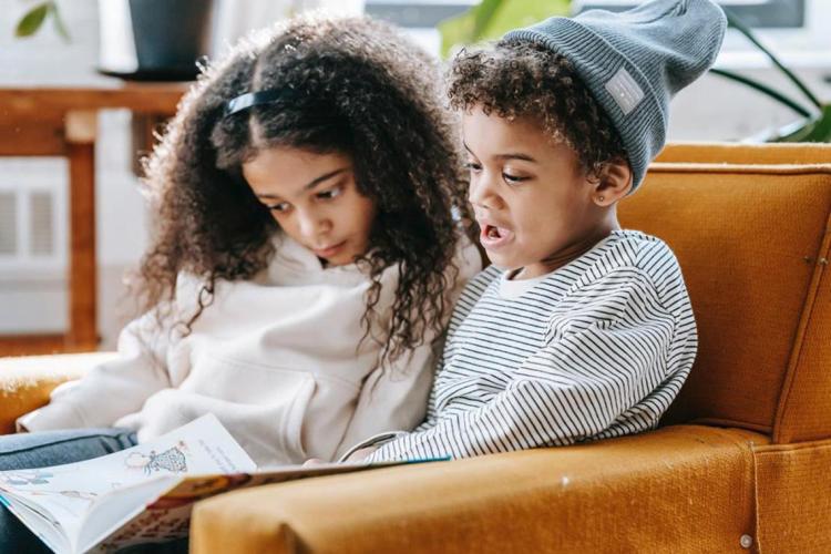 two young Black children read a picture book