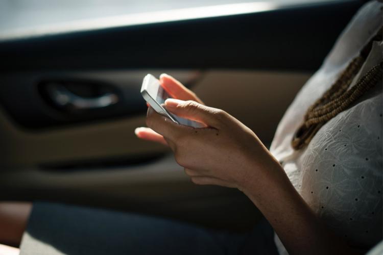 Photo of woman in car using cellphone
