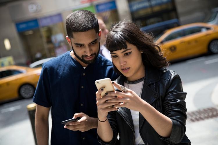 Two people playing Pokémon GO outside the Nintendo flagship store in New York