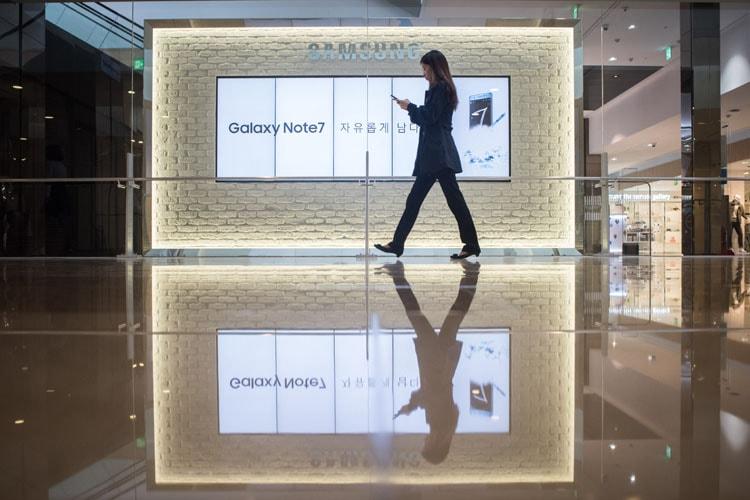 A woman walks in front of an advertisement for a Samsung phone in Korea