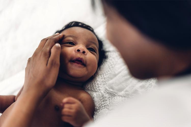 a Black mother holds her infant child