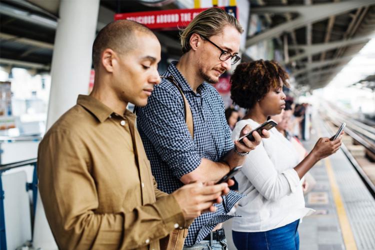 photo of commuters looking at their smartphones